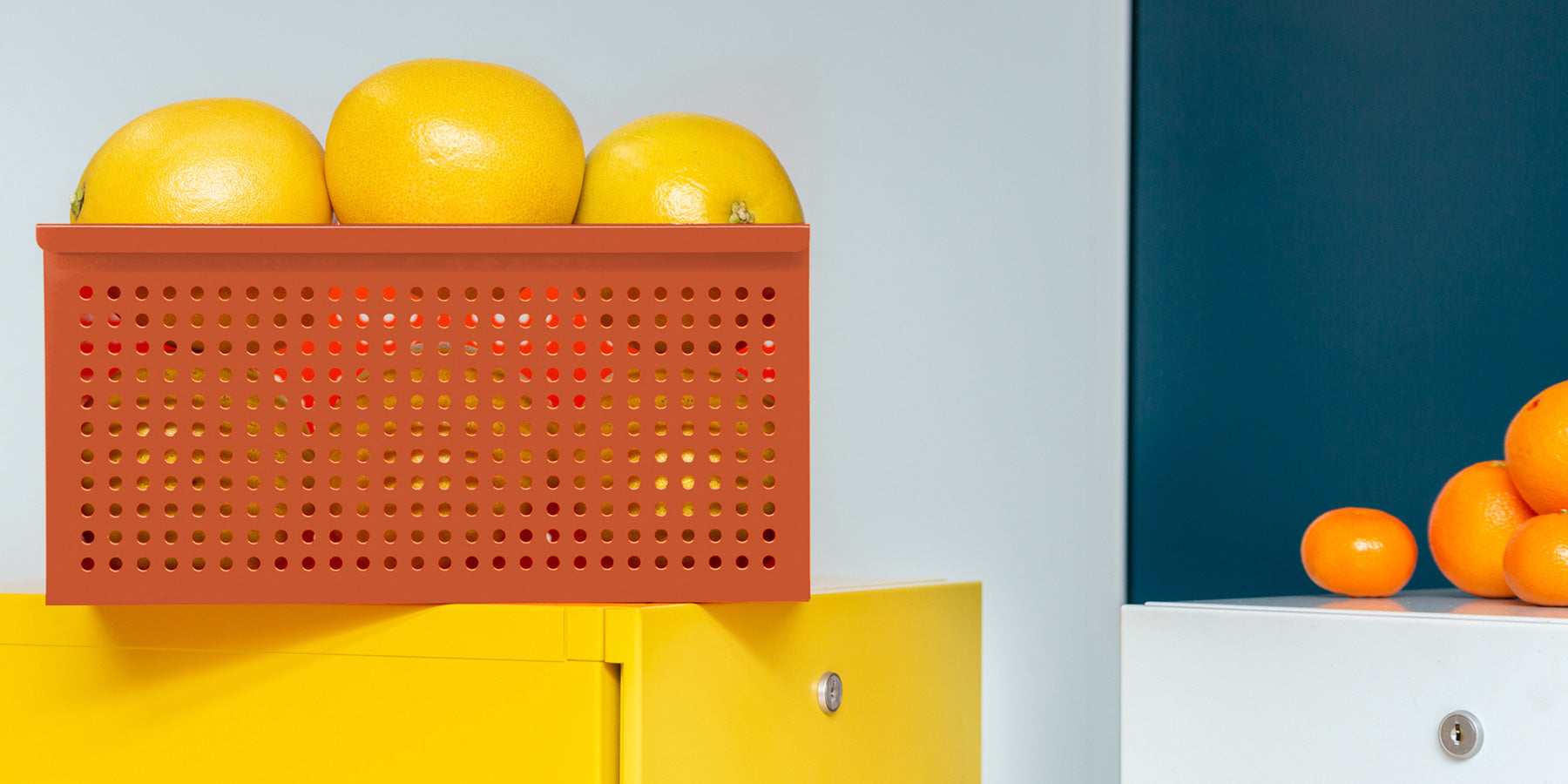 Heartwork perforated basket in orange staged with lemons