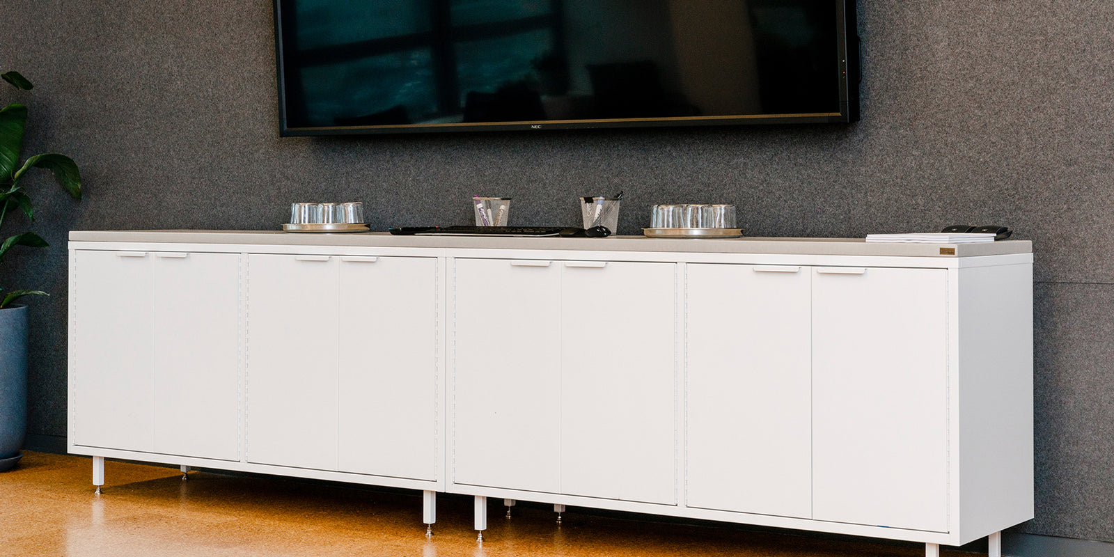 Heartwork Active Duty A/V credenza in white with tv set above in office setting