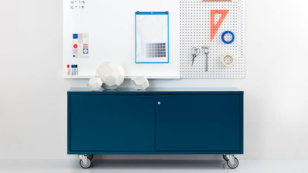 Heartwork storage credenza in blue against a white wall in a staged setting