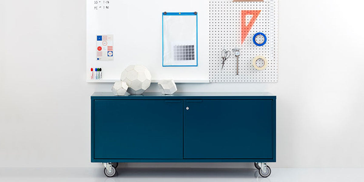 Heartwork storage credenza in blue against a white wall in a staged setting