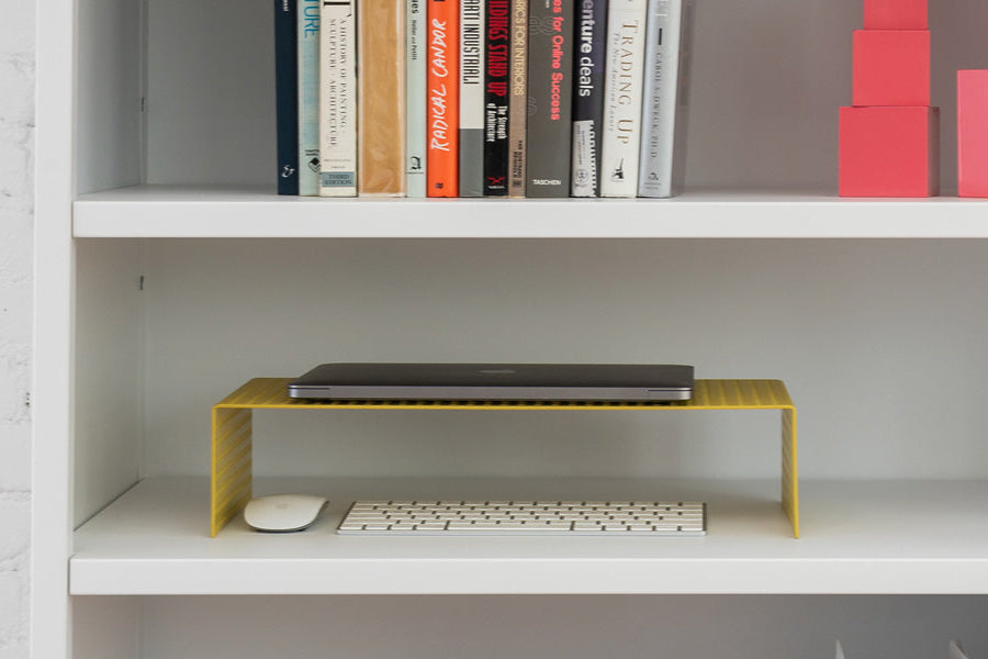 Heartwork Monitor Stand in yellow on shelf with laptop, keyboard and mouse